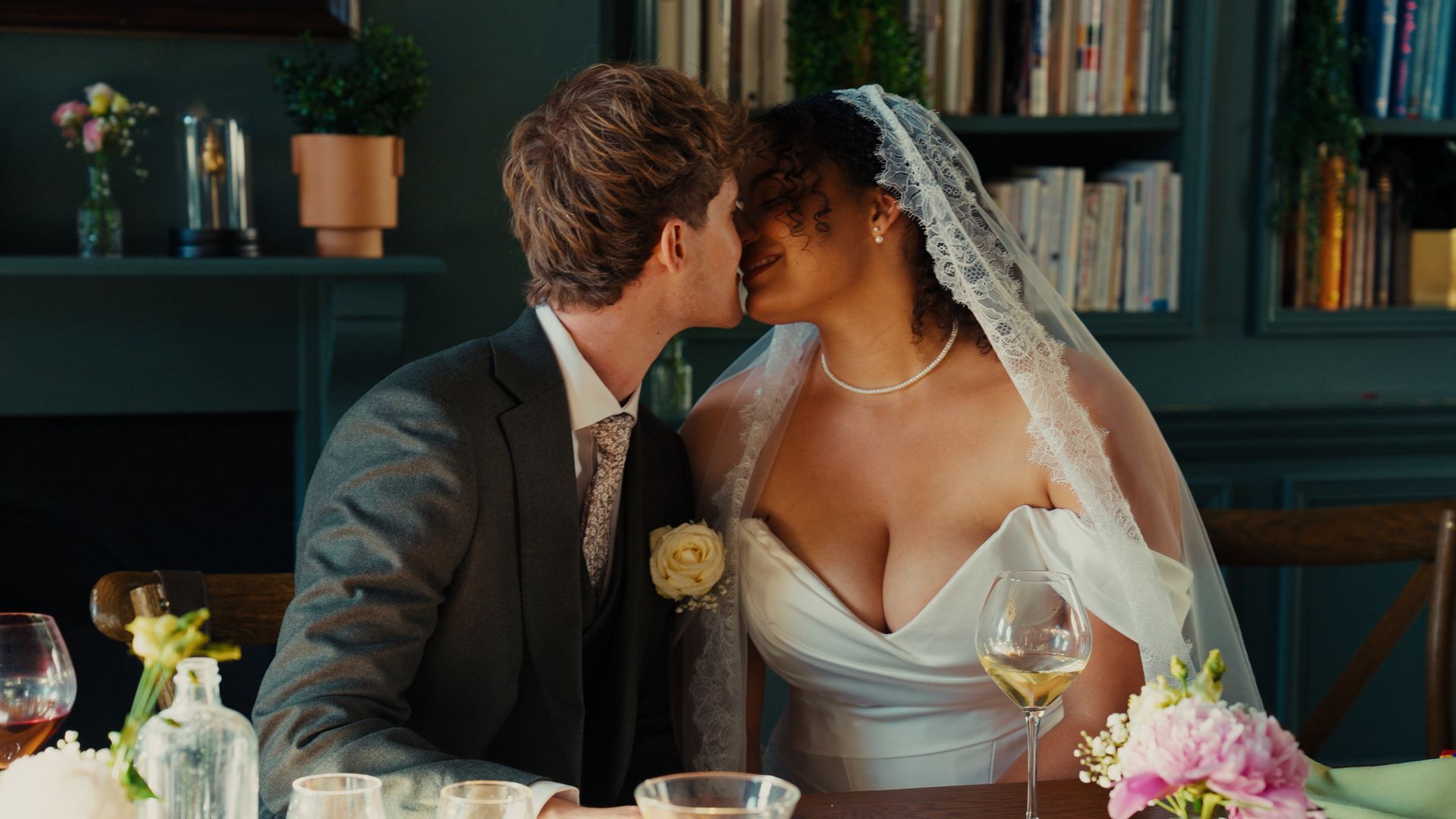 A couple sharing a kiss among the bookshelves